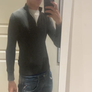 Grön halvzip tröja - Säljer en halvzip i olivgrön från jack &jones. Säljer den pga den är för liten, jag är 180 cm och väger 60 kg så skulle gissa att den skulle sitta perfekt om du är 165-175. Litet hål i högra armhålan men ser värre ut än vad det är. Hålet ser stort ut för att tröjan är så tajt så hålet är inte jätte stort. Be en i din familj sy den om du tycker hålet är för stort!😁