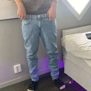 Slim fit ljusblå jeans från H&M - Slim fit jeans från H&M i ljusblå denim. Klassisk femficksmodell med normal midja och raka ben. Materialet är 99% bomull och 1% elastan för lite stretch. Perfekta för dig som gillar en clean och enkel stil.