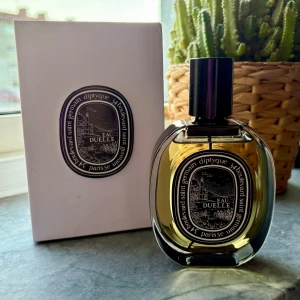 Diptyque Eau Duelle Eau de Parfum - Diptyque Eau Duelle 75ml. Sprutad några gånger. Se mängd på bild. Har kryddiga, trä och vaniljnoter. Väldigt fin och unik vanilj parfym. 