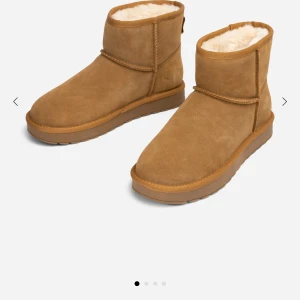 Bruna uggs från skopunkten! St 39 - Säljer ett par mysiga bruna uggs med mjukt foder. De är tillverkade i mocka och har en klassisk design med rund tå och låg klack. Uggsen är använda men fortfarande väldigt fina! Sulorna är slita se bild (4) Sedan har även sulorna gått upp lite på undersida men det är inget som märks av då man går med skorna🙂💗Skorna är rengjorda, sprutade med sko deo, använt borste för att rugga upp fodret inuti och även impregnerat skorna så dem håller under regn ☔️ Hör av er vid fler frågor 🥰🥰
