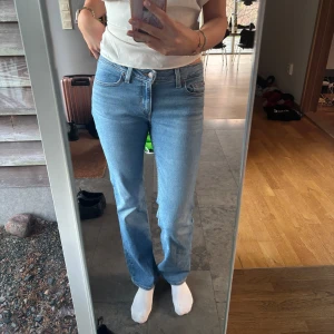 Ljusblå jeans från Levi's - Snygga ljusblå jeans från Levi's med klassisk femficksdesign och knappgylf. De har en rak passform med låg midja och är perfekta för en avslappnad stil. Levi's-logga syns på baksidan av midjan. Använd få gånger, köpt förra sommarn för 1200kr. Passar längre tjejer (jag är 178)