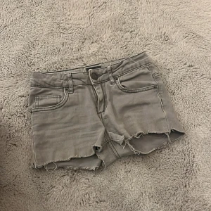 Grå jeansshorts - Säljer ett par grå jeansshorts från Cubus💕Det var ett par skinny jeans men jag klippte de till jeansshorts💞 De är i storlek 140 men de är stora i storleken eftersom midjemåttet är 31 cm💞 De är i superbra skick och aldrig använda🩷Säljer på grund av att dom är för små🫶🏻Kan skicka bilder på om man vill för ja har några gamla bilder🩷