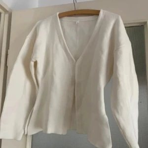 Vit kofta från Zara - Säljer en stilren vit kofta från Zara. Den har en enkel design med långa ärmar och en öppen front utan knappar. Perfekt för lager-på-lager och passar till många olika outfits. Säljer den ej passade mig och är köpt här på plick!