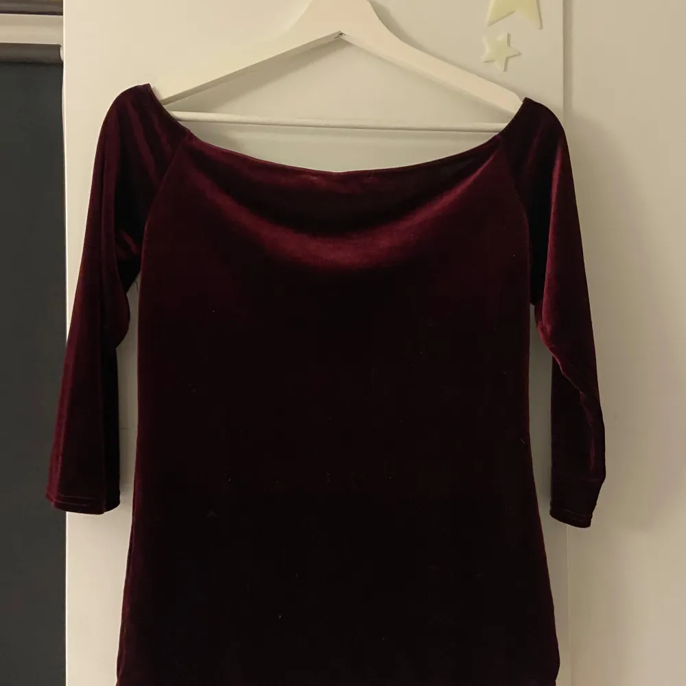 Snygg vinröd topp i mjuk sammet från Dorothy Perkins. Den har en elegant v-ringning och trekvartsärmar, perfekt för en stilren look. Passar utmärkt till både jeans och kjol.. Yläosat.