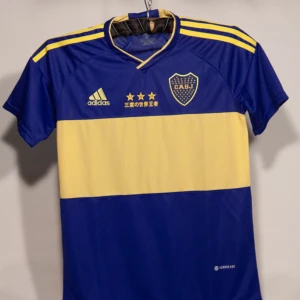 Boca Junior Copa Del Mundo tröja - Den hära tröjan gjordes när Boca Junior vann sin tredje seger i Copa del Mundo (klubb VM). Dom tre stjärnorna står för varje år dom vann.  Storlek M Tröjan är helt ny!!