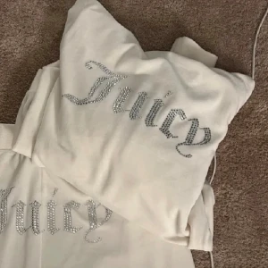Vit Juicy Couture set med diamanter - Säljer ett vitt set från Juicy Couture med glittrande text på ryggen och bakdel. Jackan är i storlek L. Byxorna är också i storlek L❤️