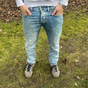 Blå jeans från Weekday - Snygga blå jeans från Weekday med en regular tapered passform. De har en klassisk femficksdesign och är perfekta för en avslappnad stil. Jeansen har en knappgylf och är tillverkade i ett slitstarkt denimtyg.