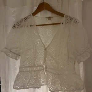 Vid broderad blus  - Vit topp. Storlek 44 men passar mindre också. Har 36 och sitter fint ändå.
