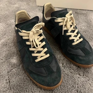 Maison margiela - Ett par snygga maison margiela sneakers i moka. Skorna är blå och skicket är ungefär 7/10, därför har jag även sänkt priset. Skriv om ni har några funderingar eller vill ha fler bilder! Låda och dustbag ingår 