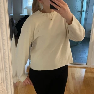 Vit stickad tröja - Säljer en stilren vit stickad tröja med rund halsringning. Tröjan har långa ärmar och en avslappnad passform. 