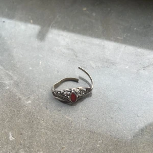 Silverring unik - Unik silverring med en vacker röd sten i mitten och detaljerat mönster runt om. Ringen har en öppen baksida vilket gör den justerbar. Perfekt för dig som gillar smycken med vintagekänsla och fina detaljer.