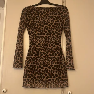 Leopardmönstrad långärmad kortklänning - Jättefin leopard klänning. Nyskick med fin öppen rygg! Skulle gissa att den är i storlek xs/s 💗
