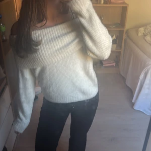 Vit offshoulder stickad tröja - Mysig vit stickad tröja med offshoulder-design och bred ribbad kant upptill. Långa ärmar och mjukt material. Använd fåtal gånger😽💕