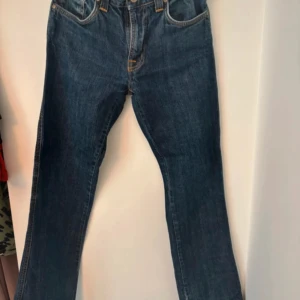 Blå Nudie Jeans  - Säljer ett par klassiska blå jeans från Nudie Jeans, modell Low Jim. Jeansen har raka ben, fem fickor och snygga kontrastsömmar.  (Pris går att diskutera)