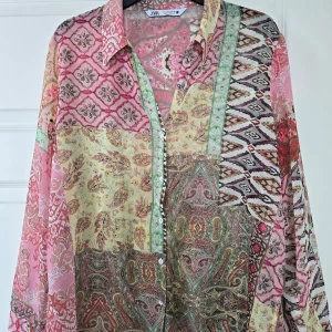 Mönstrad skjorta från Zara - Färgglad skjorta från Zara med patchworkmönster i rosa, grönt, gult och brunt. Skjortan har långa ärmar, klassisk krage och knäppning framtill. Tunt och luftigt material, perfekt för vår och sommar.