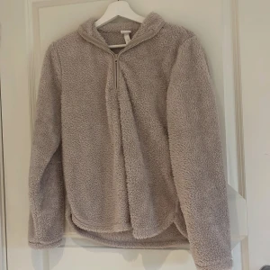 Beige fleecekofta med dragkedja från Cubus - Mysig beige fleecekofta från Cubus med halv dragkedja framtill och hög krage. Perfekt för kyliga dagar och enkel att matcha med andra plagg. Supermjuk och fluffig känsla.