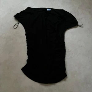 Svart figurnära kortärmad tröja i bra skick! - Svart figurnära tröja från H&M Divided i enkel och tight modell. Klänningen har korta ärmar i en snygg passform. Perfekt till sommaren eller när du vill ha en enkel look. 