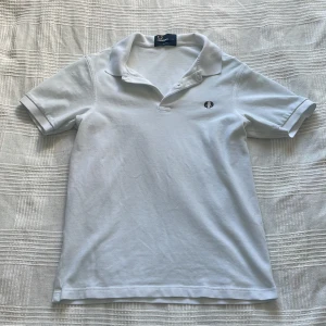 Fred Perry Piké - Säljer en klassisk vit pikétröja från Fred Perry i slim fit-modell. En perfekt Piké inför Sommaren 2025! 🍀. Stilren piké i storlek S. Säljer då den börjar bli tajt. Bara höra av dig vid frågor! 🙂