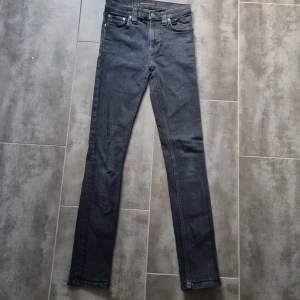 Mörkblå skinny jeans från Nudie Jeans - Säljer ett par mörkblå skinny jeans från Nudie Jeans. Klassisk femficksmodell med normalhög midja och raka ben. Perfekta för dig som gillar en tidlös och enkel stil. Passar till det mesta och är riktigt bekväma.