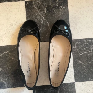 Ballerinaskor - Svarta blanka ballerinaskor. Använda men fortfarande i bra skick. Ena sulan har börjat lossna lite i kanten. 