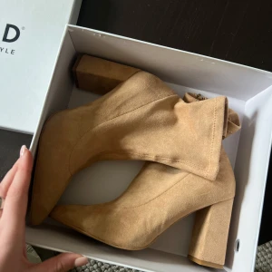  mocka boots - Säljer ett par snygga beiga boots i mocka med hög klack och spetsig tå. Skorna har dragkedja på insidan och en stilren design som passar perfekt till höst- och våroutfits. Helt nya!
