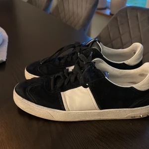 Svarta och vita sneakers med nitar - Säljer ett par svarta valentino flycrews i okej skick. 2 nitar saknas och lite små detaljer på dom. Riktigt bekväma och stilrena skor 
