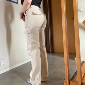 Cargopants - Beiga cargopants från Zara med hög midja och raka ben. Byxorna har flera fickor på sidorna och knäppning framtill. Säljer då de är för små.