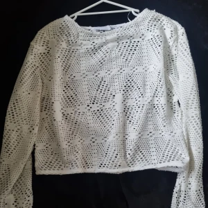 Vit virkad croppad tröja från 157 - Säljer en vit virkad croppad tröja från 157. Tröjan har lång ärm och storlek 5. Perfekt att styla över ett linne eller topp.