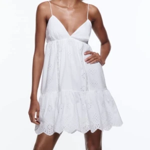 Vit klänning med broderade detaljer - Säljer en söt vit kortklänning med smala axelband och v-ringning från Zara💕Använd endast 1 gång