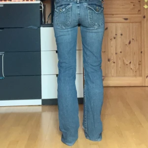 True Religion bootcut jeans - Skitsnygga lågmidjade jeans från true religion. Köpt secondhand 💕 📏 Mått (mätt platt): Midjemått: 39cm Gren: 21cm Innerbenslängd: 80cm (tidigare 81cm) Storlek W30 Jag är 170cm och bär S/36 Obs! Har sytts upp längst ned och är smått skadade vid fickorna :) Hör av dig vid fler frågor!💕