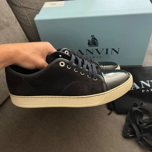Lanvin skor - Säljer dessa snygga Lanvins i rätt bra skick. Mockan är navy men är smutsig så ser mer svart/brun ut. Toeboxen är lite creasade och har små repor men glanset är de inget fel på. Box, dustbag och snören medföljer. Storlek UK7 ~ 41/42