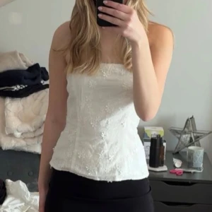 Vit broderad tubtopp med blommor - Vit blommig tubtopp i storlek 36. Helt ny, lite för stor för mig tyvärr