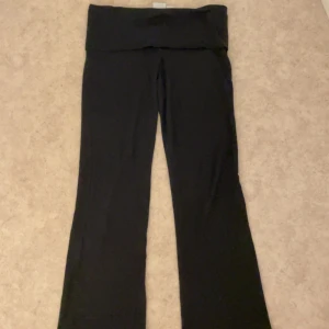 Svarta bootcut yogabyxor - Svarta yogabyxor med bred, vikt linning och bootcut-ben. Mjukt och stretchigt material som sitter skönt på kroppen. Perfekta för chill eller träning. Klassisk och enkel design som funkar till det mesta.