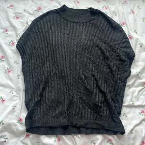 Mörkgrå ribbad tröja från H&M - Säljer en mörkgrå glittrig ribbad tröja från H&M i storlek S. Perfekt för fester,utekvällar och andra dagar som man vill vara lite finklädd! Använd 1-2 gånger! 