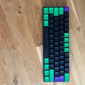 Det finns ingen bok på bilderna - Bilderna visar ett tangentbord (NOS C450 Mini Keyboard Pro - Riddle) och inte en bok. Ingen bokinformation kan extraheras.Det har RGB i olika färger och mönster och det är i bra skick.