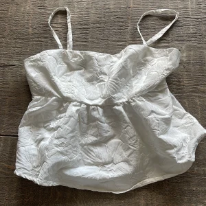 Vit blommig linnetopp Gina Tricot - Supersöt vit linnetopp från Gina Tricot med tunna axelband och broderade blommor i tyget🤍aldrig använd 