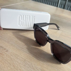 Gråa solglasögon från CHIMI - Supersnygga chimi-solglasögon, model #005 och färg ginger (grå). Knappt använda över huvudtaget, superbra skick! Orginalpris 1500kr, förstår det som att de inte längre säljs. En oanvänd puts duk är även med i fodralet.