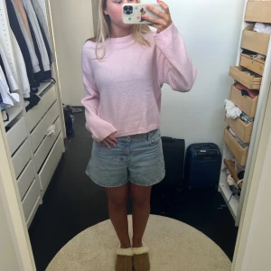 Ljusrosa stickad tröja  - Supermjuk ljusrosa stickad tröja med rund hals och långa ärmar. Tröjan har en loose och lite croppad passform, perfekt för att slänga på sig över ett linne eller t-shirt. Enkel och stilren design som är lätt att matcha.