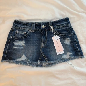 Mörkblå jeanskjol med låg midja från Gina Tricot - Trendig helt oanvänd Gina Tricot young jeanskjol med lappen kvar. Helt slutsåld. Pris kan diskuteras.