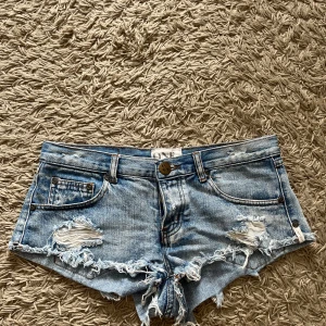 Lågmidjade ONE TEASPOON shorts - Snygga lågmidjade ljusblå jeansshorts från ONE TEASPOON. Saknar storlek men passar xs-s! Säljer då de inte kommer till användning🥰shortsen är i bra skick!! Nypris: 1000