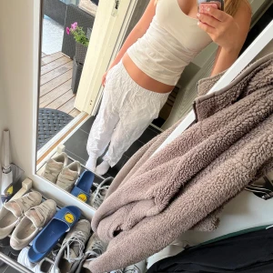 Vita linnebyxor med avslappnad passform - Säljer ett par vita linnebyxor med loose fit och elastisk midja. Byxorna är lätta och luftiga, perfekta för varma dagar. De har en enkel och stilren look som passar till det mesta. Supersköna att bära och lätta att matcha med olika toppar.