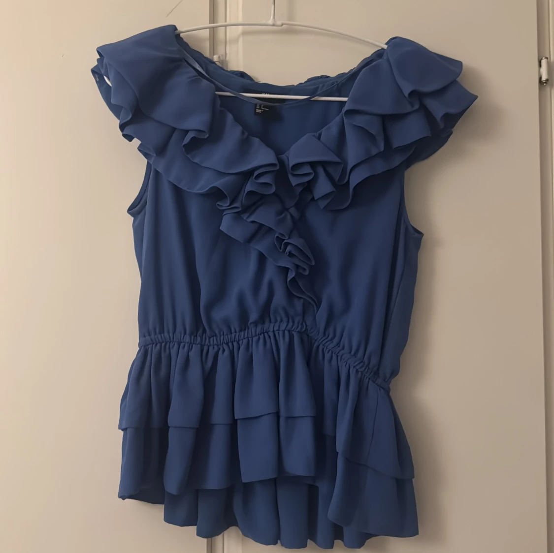 Blå volangblus med ärmlös design