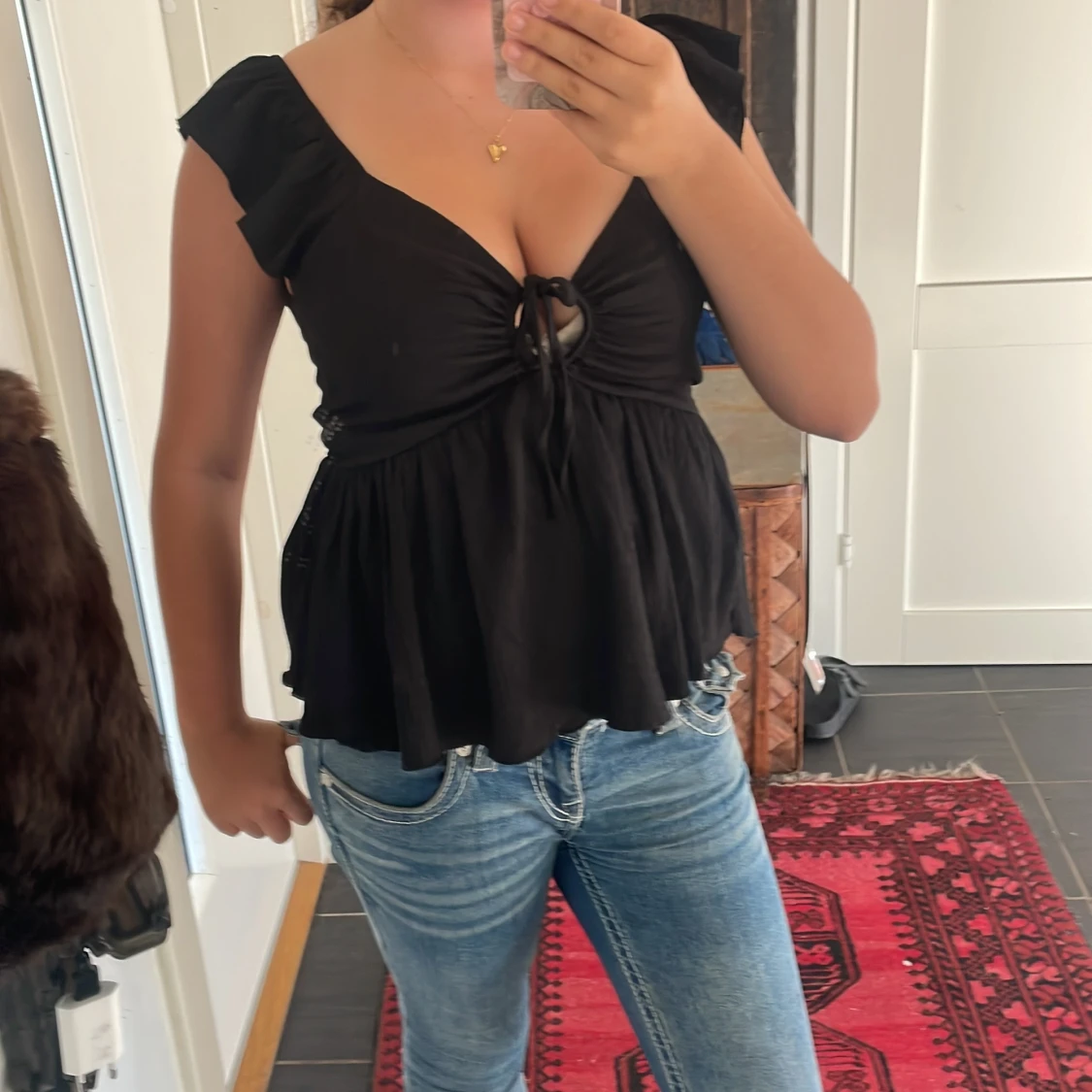 Svart blus med knyt och volang