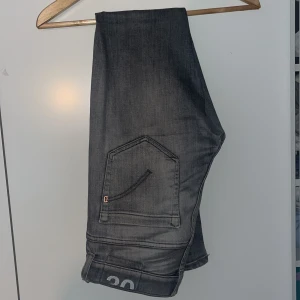 Gråa Dondup George Jeans 30 - Ett par Dondup George i fint skick, endast ett pyttelitet slitage på baksidan som ej syns vid användning. Hör gärna av er vid frågor. Storlek 30