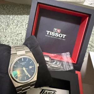 Tissot PRX blå urtavla stålarmband - Snygg Tissot PRX med blå urtavla och datumvisning. Klockan har ett stilrent, borstat stålarmband och boett i rostfritt stål. Kommer i originalask med extra länkar. Perfekt accessoar för dig som gillar klassisk och modern design. Klockan är batteri driven 