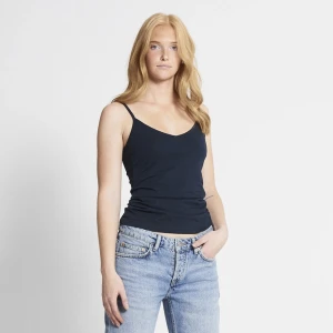 Svart linne - Enkel och stilren svart linnetopp med smala axelband och v-ringad hals. Perfekt att matcha med jeans eller kjol för en clean look. Mjuk och skön känsla tack vare bomullsmaterialet.