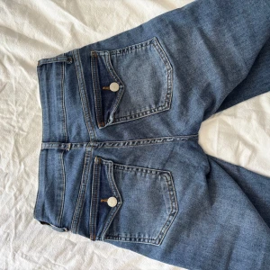 Blå bootcut jeans från Nelly - Blå bootcut jeans från Nelly med fickor på baksidan. Jeansen är low waist💕 Är använda men inget som syns☺️Pris kan diskuteras