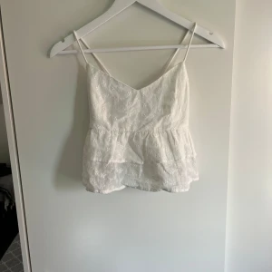 Söt vit topp - Gulligt linne i bra skick med endast en liten synlig defekt (liten fläck längst ner på höger snöre, bild 2). Toppen är från shein och i storlek S. Säljer för att jag rensar min garderob och denna tyvärr inte kommit till användning 😄