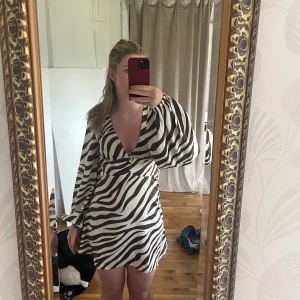 Zebramönstrad miniklänning  - Zebramönstad miniklänning i satin från NA-KD. Använd fåtalet gånger så i fint skick. Säljer då den är för liten. Hör av dig om du har frågor, pris går att diskutera🥰