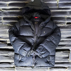 Mörkblå ralph lauren puffer - Säljer en mörkblå puffer jacka från ralph lauren🙌🏻 skulle säga på gränsen av bra skick nästan acceptabelt skulle jag säga finns några små hål 🕳️ passar tyvärr inte mig i armarna men passar mig i läng och jag är 171/172 kom med bud/prisförslag eller frågor start pris 1100kr💵 dm för mer bilder av defekterna!🙌🏻